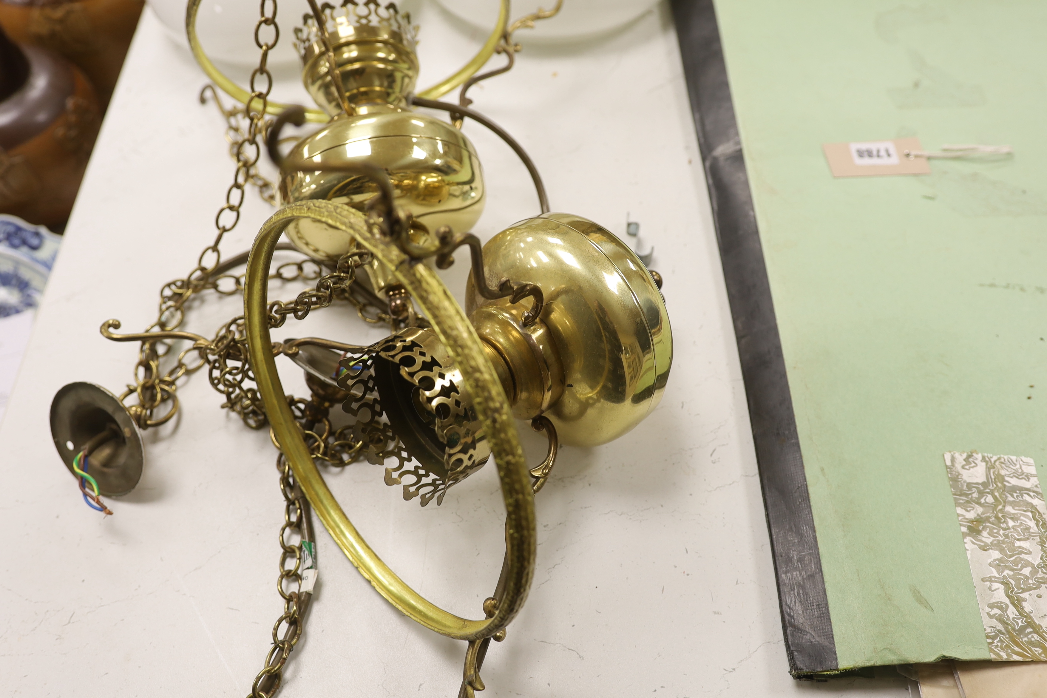 A pair of brass hanging lights with opaque glass shades